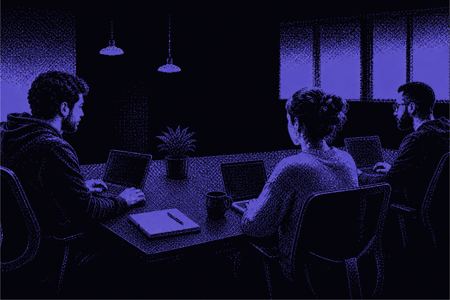 A software team working together on multiple screens in their office